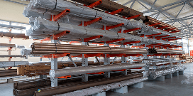 A cantilever rack holding various piping materials sits in a warehouse facility