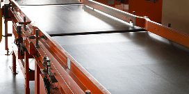A conveyor belt on the floor of a warehouse facility