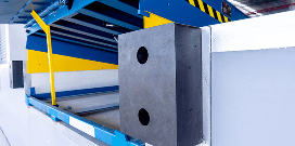 A blue and yellow dock leveler ready to be utilized to increase industrial loading efficiency