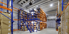 Rows of blue and orange mezzanine platforms holding a variety of packages in a warehouse