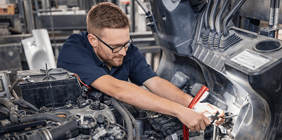 Professional reviewing data on multiple monitors in a control room, focused on analyzing real-time operational metrics.