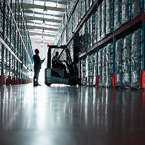 A doctor holding a pill bottle checks a tablet in a room with medications on shelves